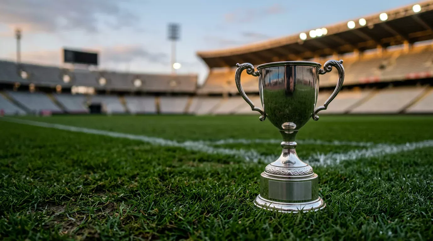 Trofeo genérico plateado de campeonato de fútbol sobre cesped natural en un estadio